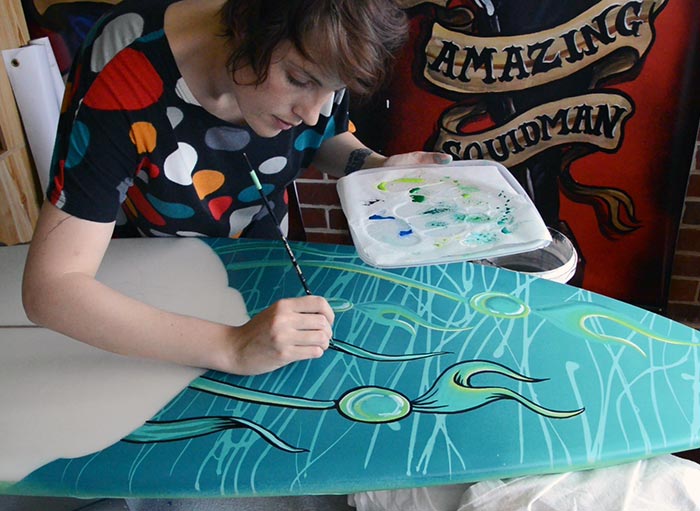 Fieldey hand-painting a surfboard artwork