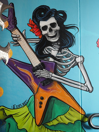 Female skeleton playing an electric guitar